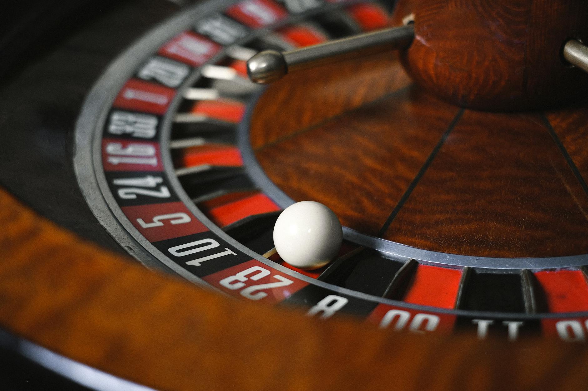 Detailed close-up image of roulette wheel highlighting numbers and spinning ball in a casino setting
